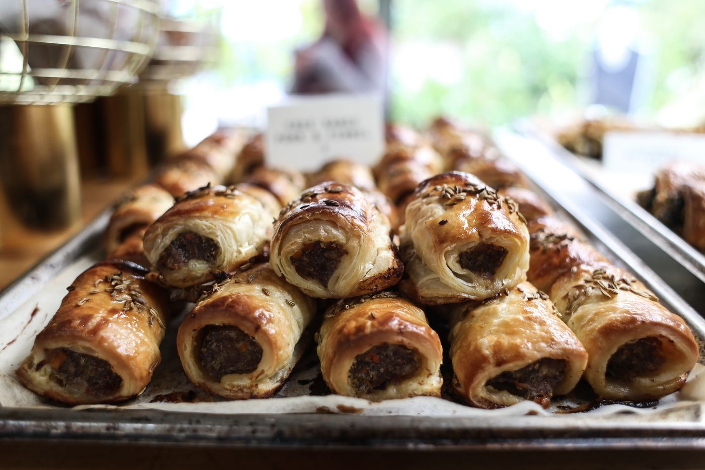 Sausage rolls lined up on a baking tray